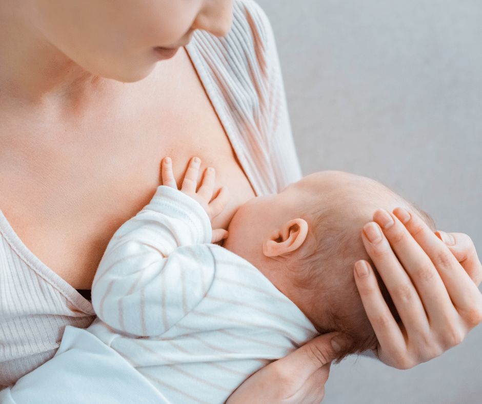 A parent breastfeeds a newborn